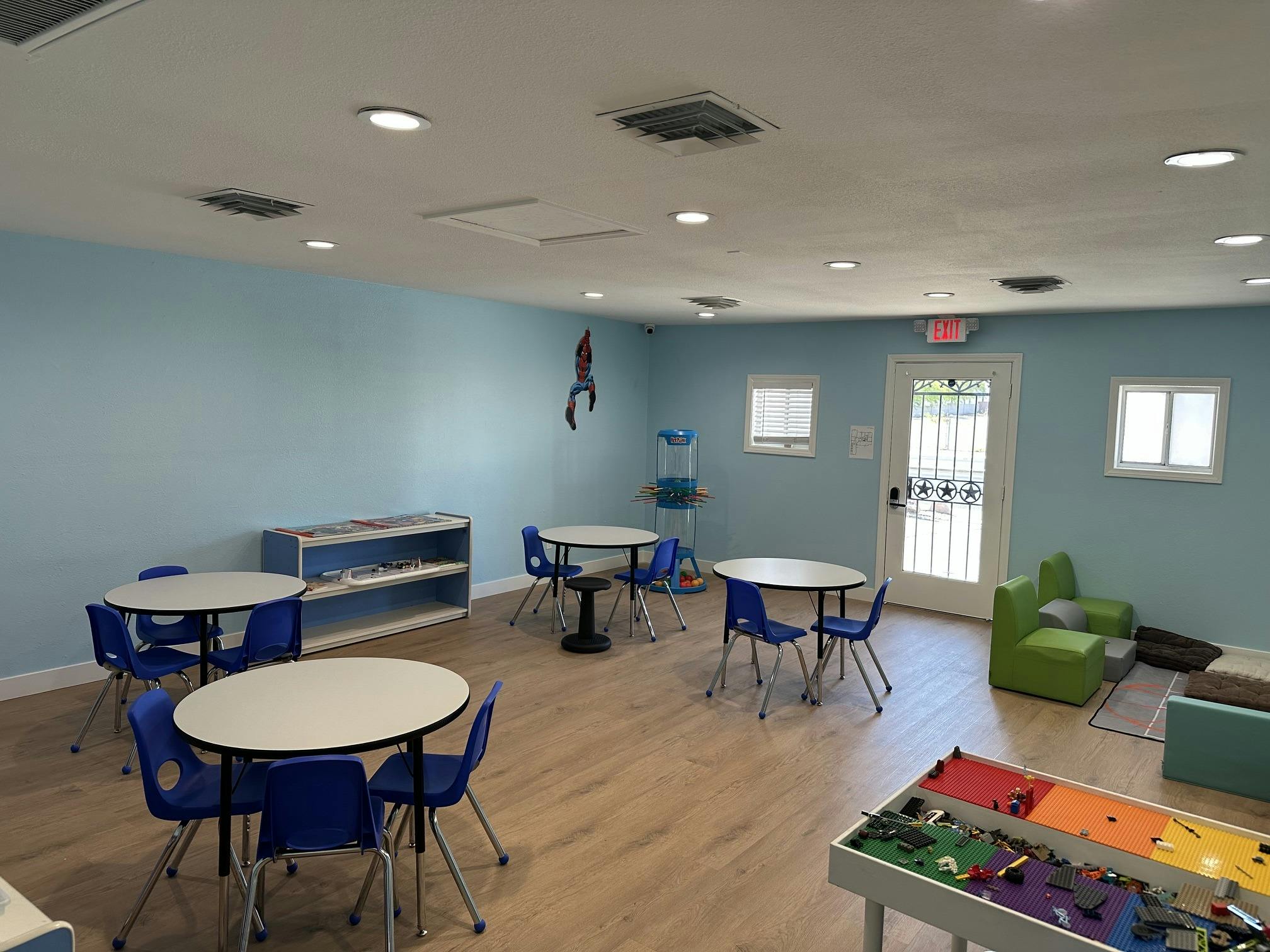 Empty playroom with tables chairs and a toy building block table
