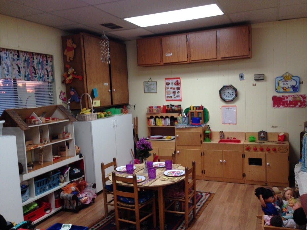 Playroom with a small table and chairs, toy kitchen, and dollhouse