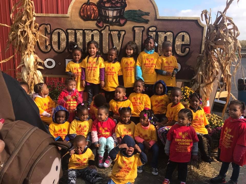 Group of children in front of a sign that says "County Line"