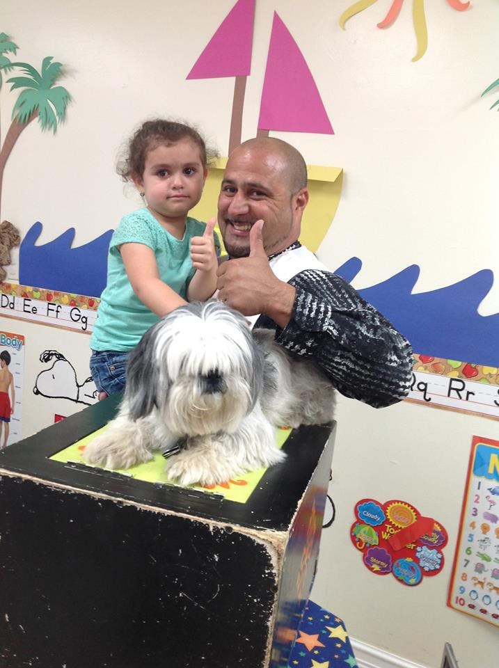 Person and child giving thumbs up with a dog