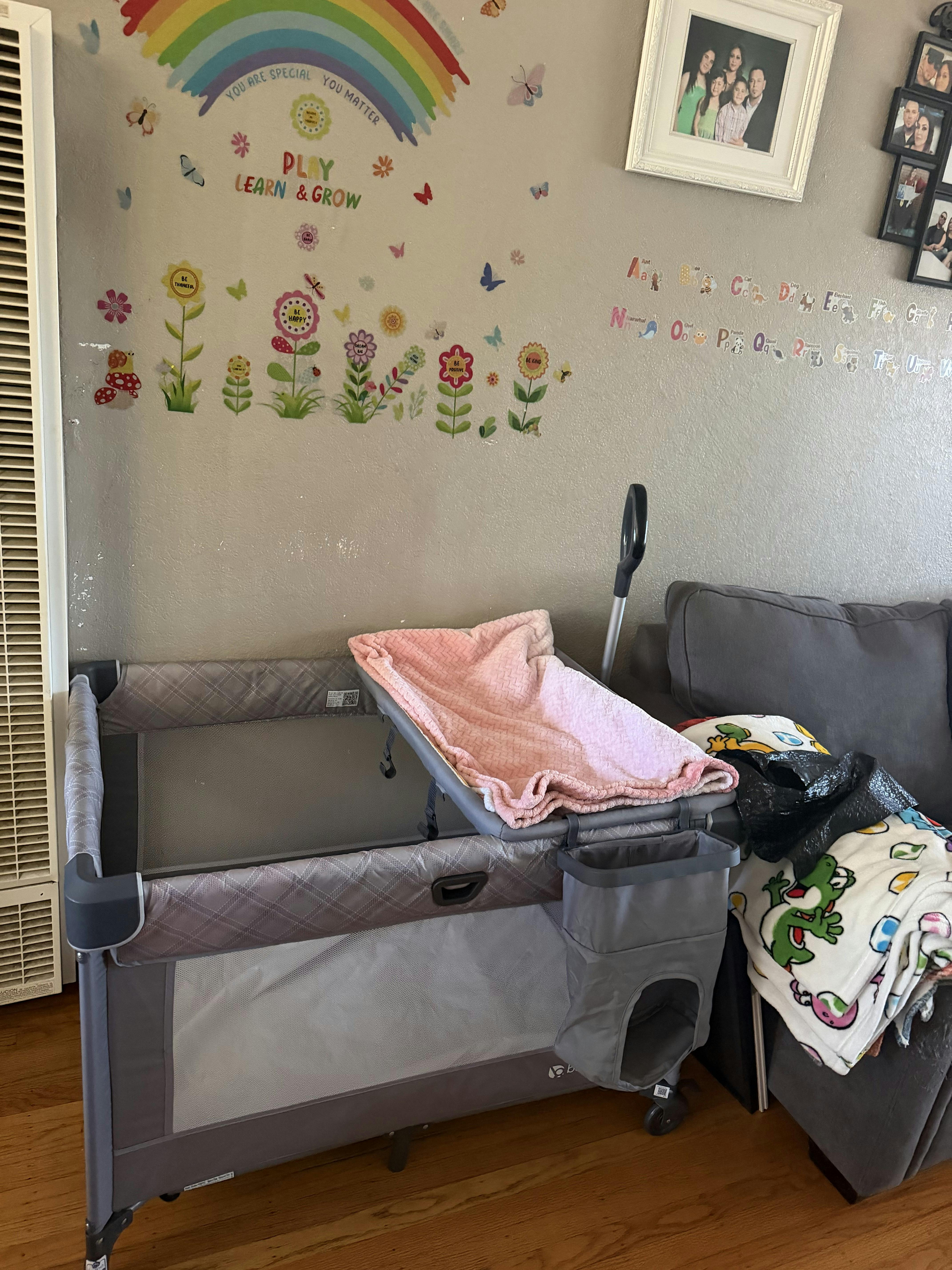 Baby play yard with a changing station and blanket in a room