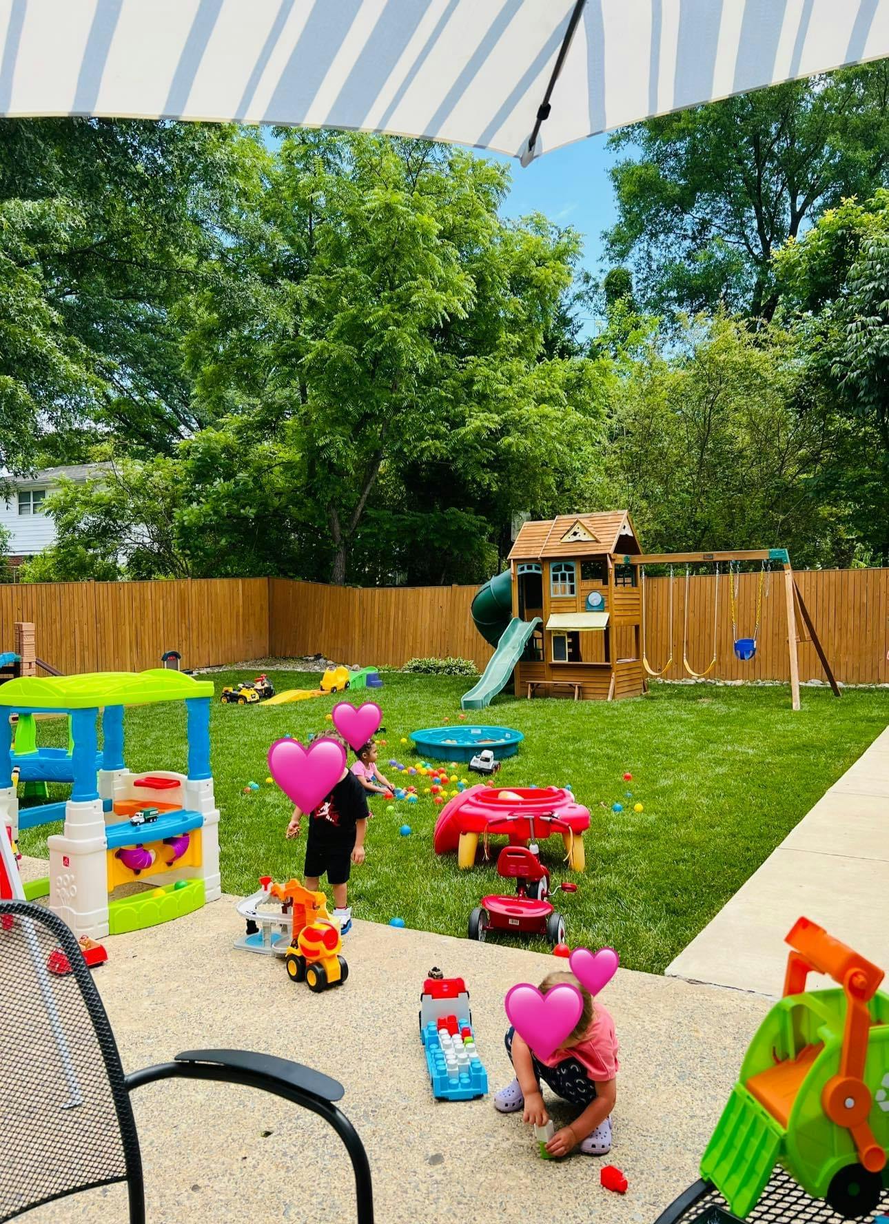 Children playing with toys in a backyard with a playset and swing set