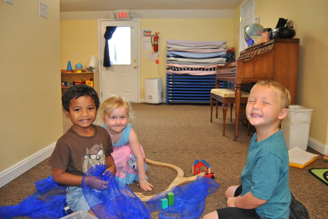 Three children playing on the floor in a room