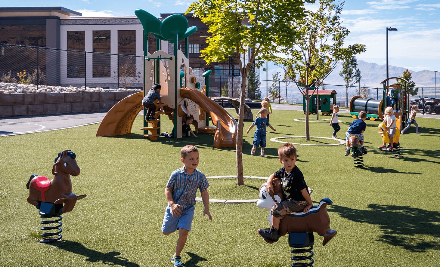 Children playing on a playground with spring riders and a slide