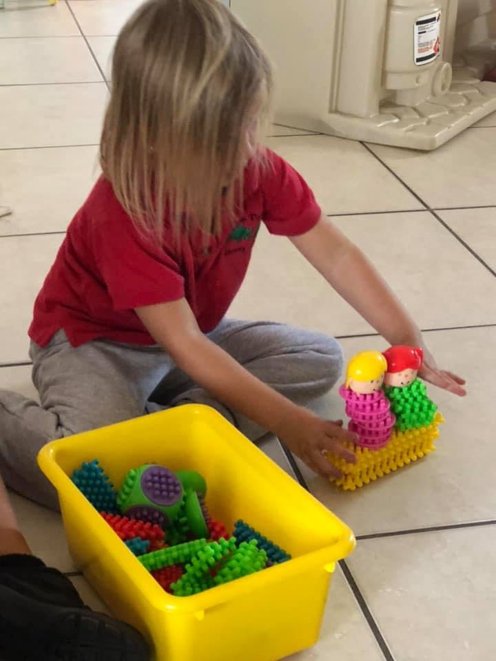Child playing with colorful interlocking toys on the floor