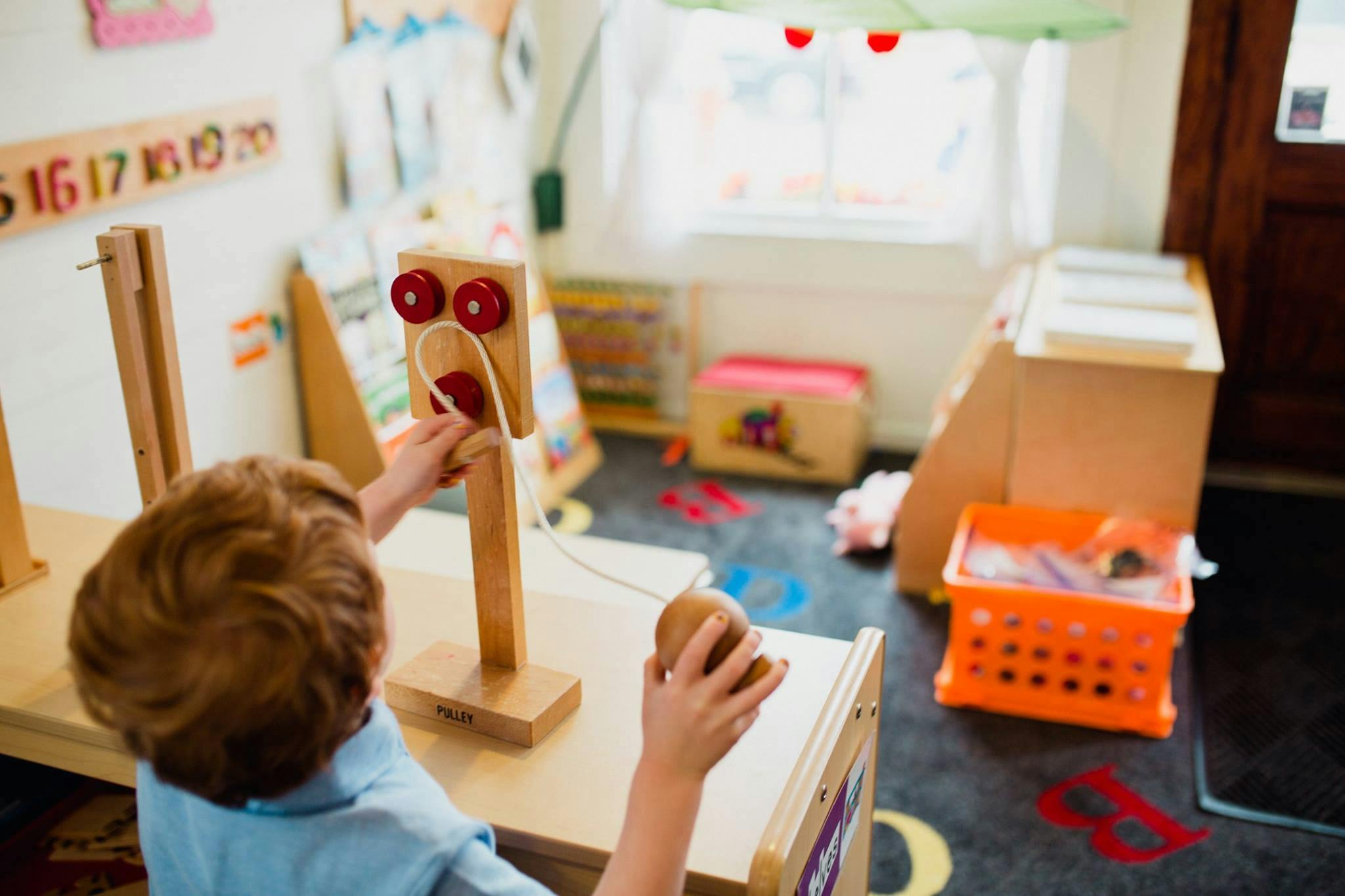 Child playing with a wooden toy in a classroom