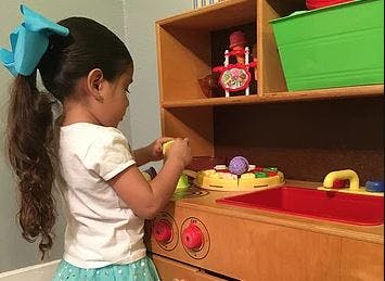 Child playing with toys on a wooden shelf