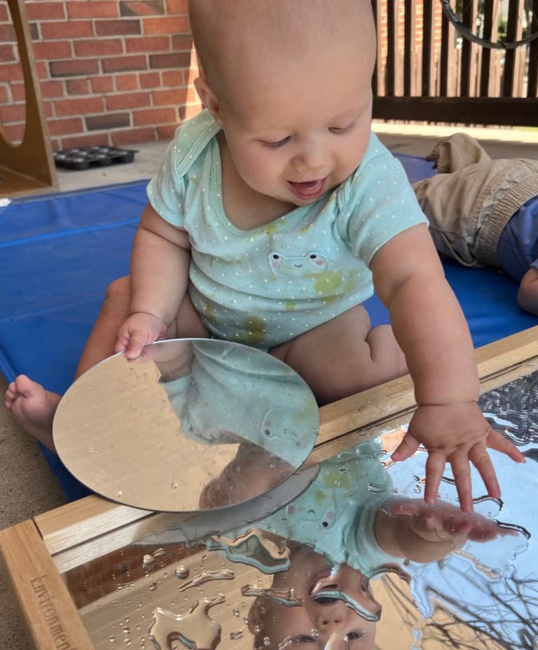 Child playing with mirrors and water