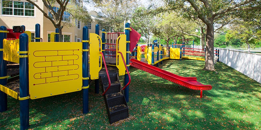 Playground with yellow and blue structure and red slide