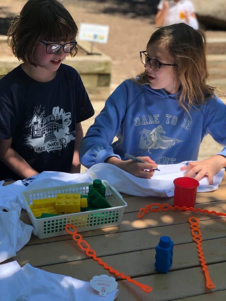 Two children at a table with craft supplies