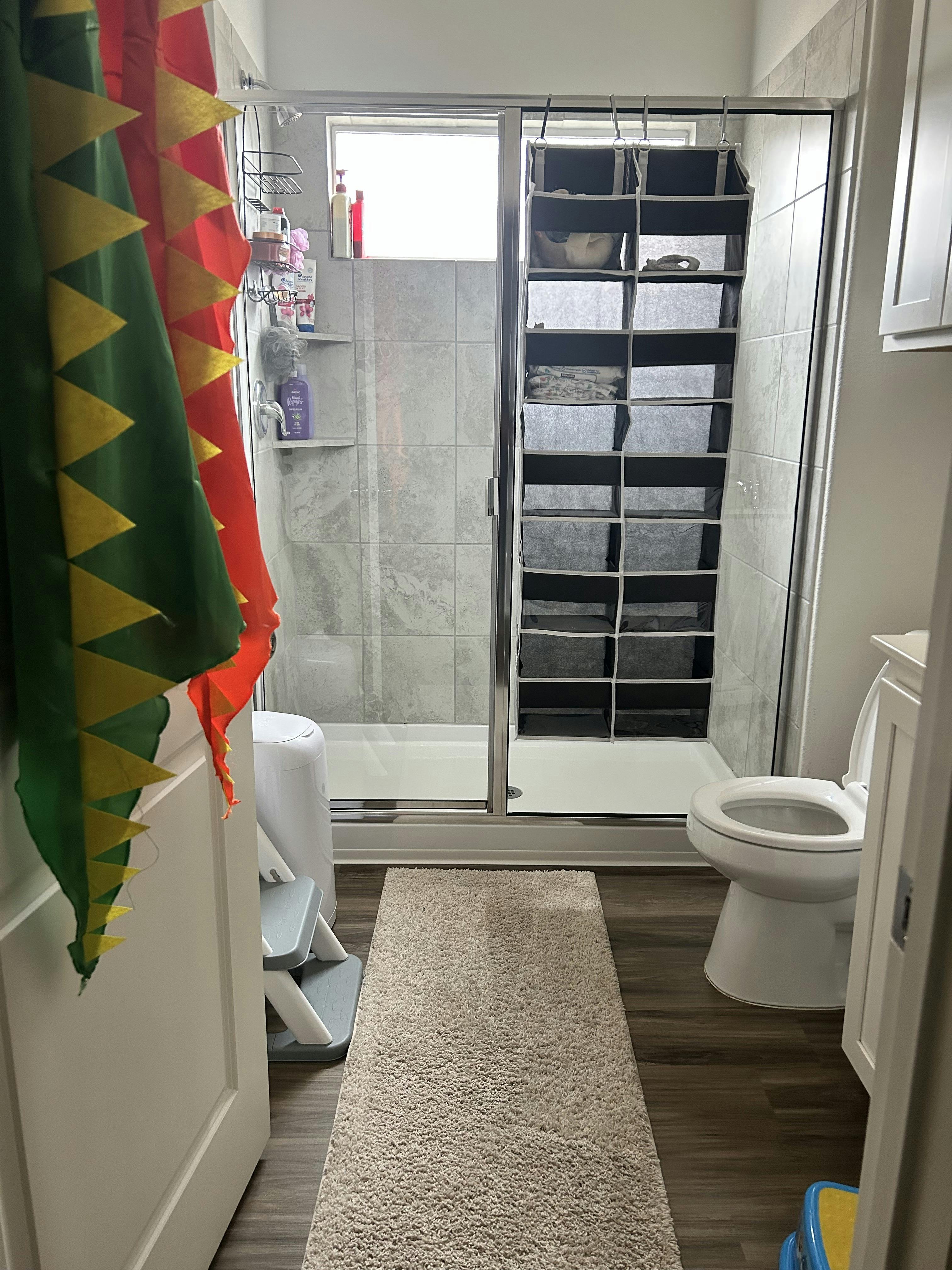 Bathroom with shower, toilet, and rug