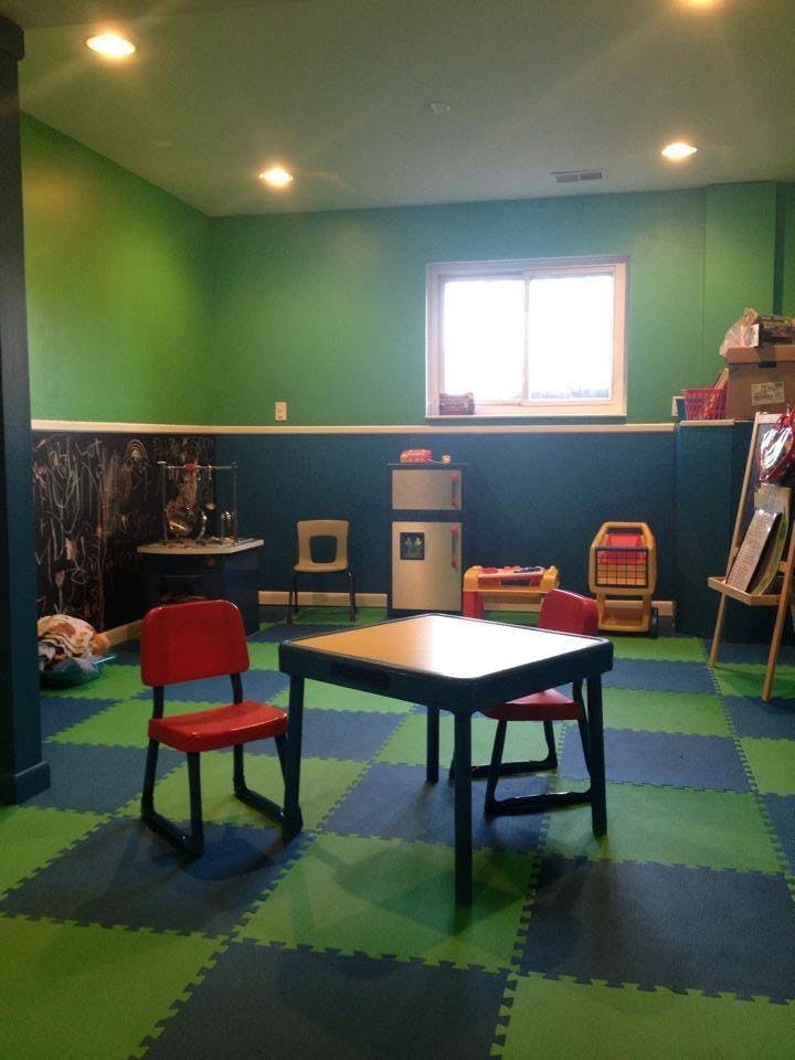Playroom with green walls, blue and green checkered floor, and small table with chairs