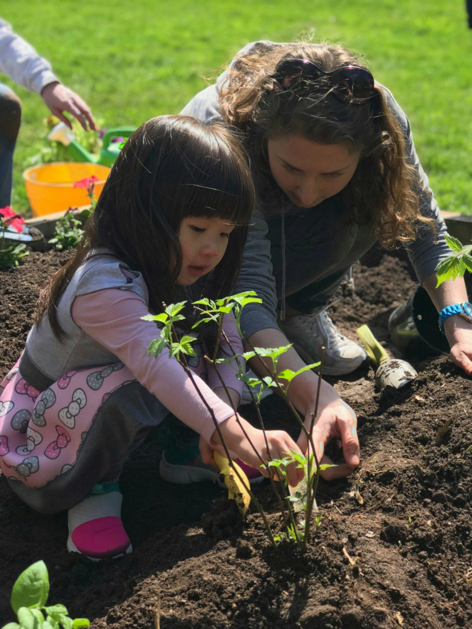 Person and child planting in dirt