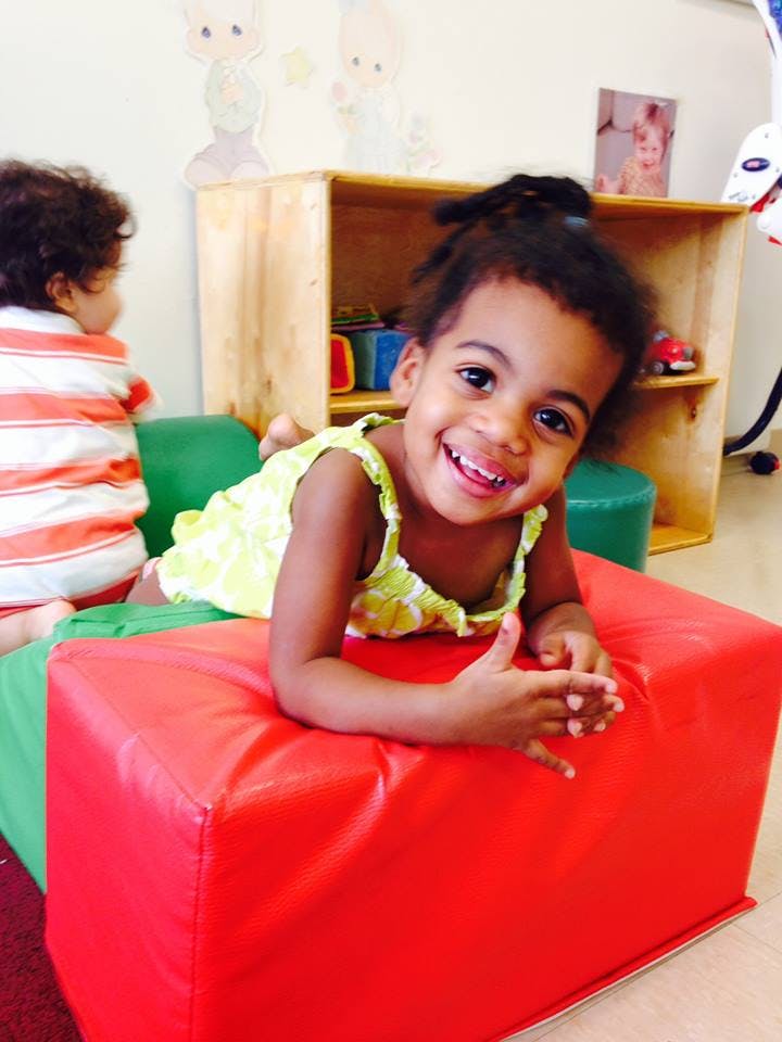 Child lying on red and green blocks