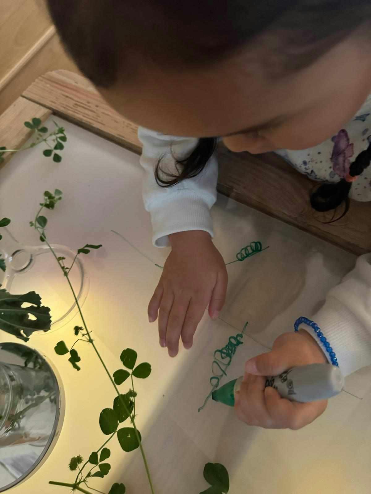 Child drawing with a green pen