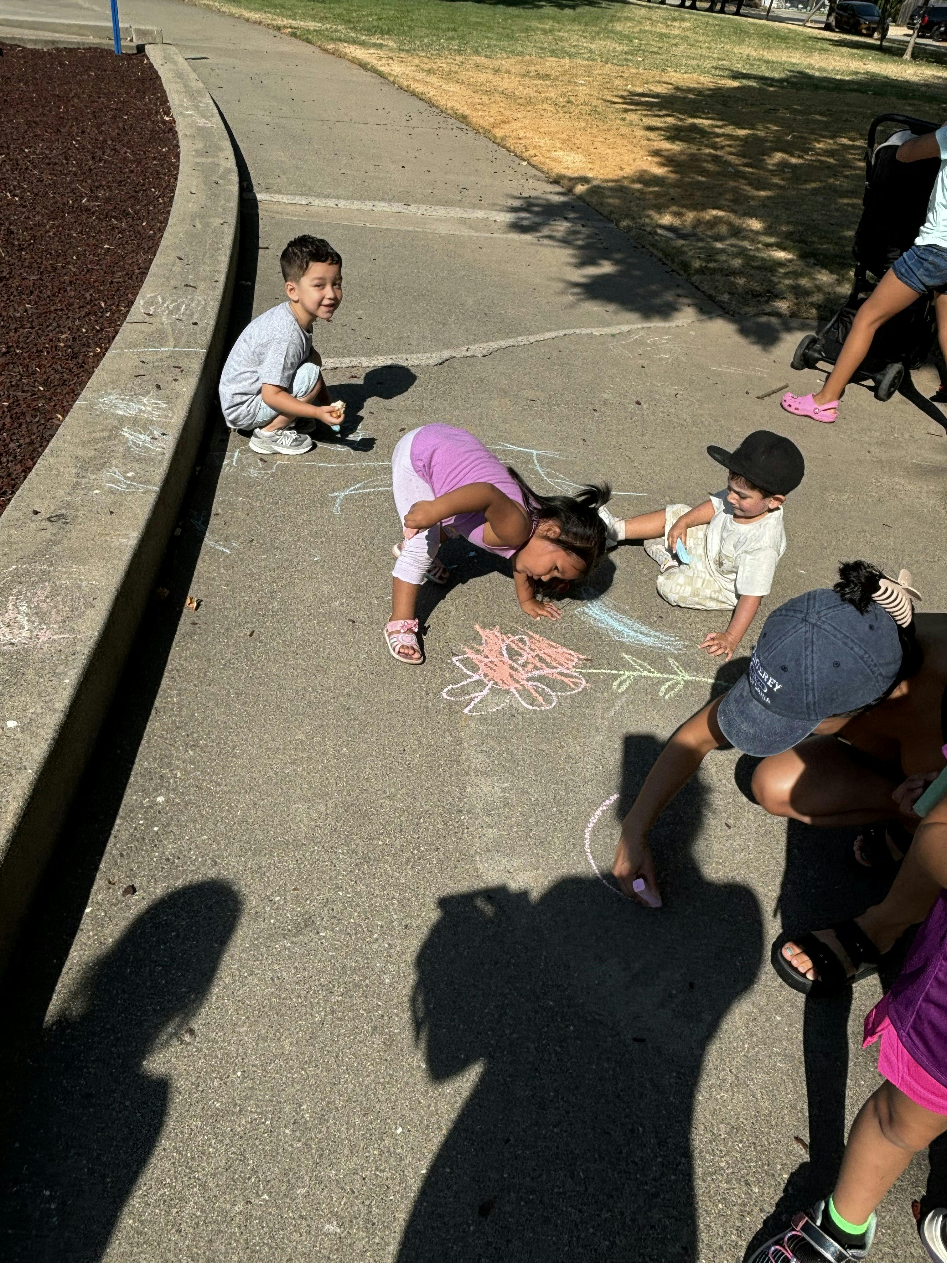 Children drawing with chalk on a sidewalk