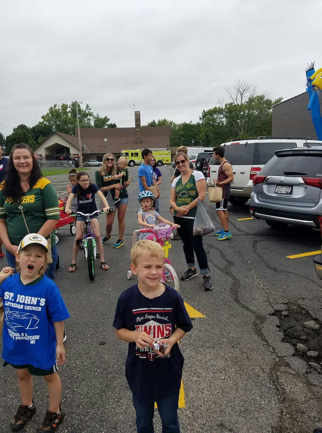 People and children gathered in a parking lot