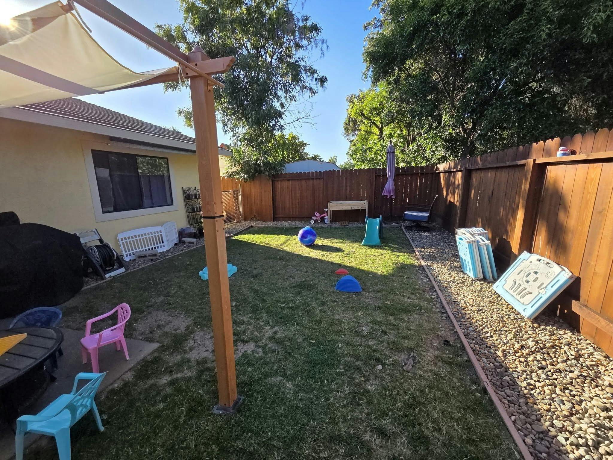 Children's play equipment scattered across a backyard lawn