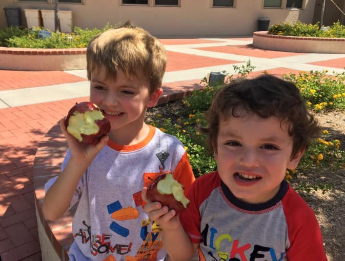 Two children holding partially eaten apples