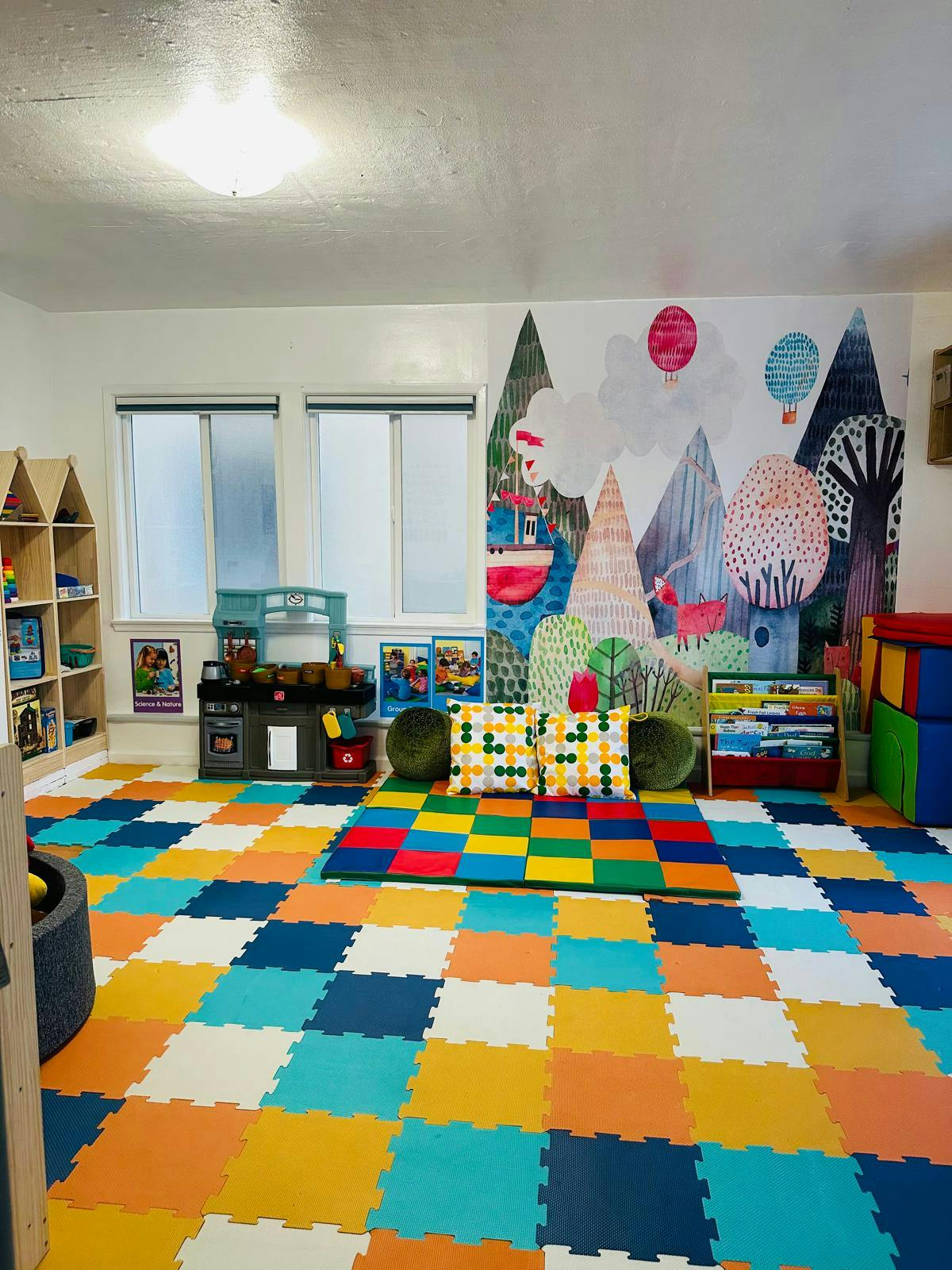 Playroom with colorful floor tiles, a mural, and play furniture