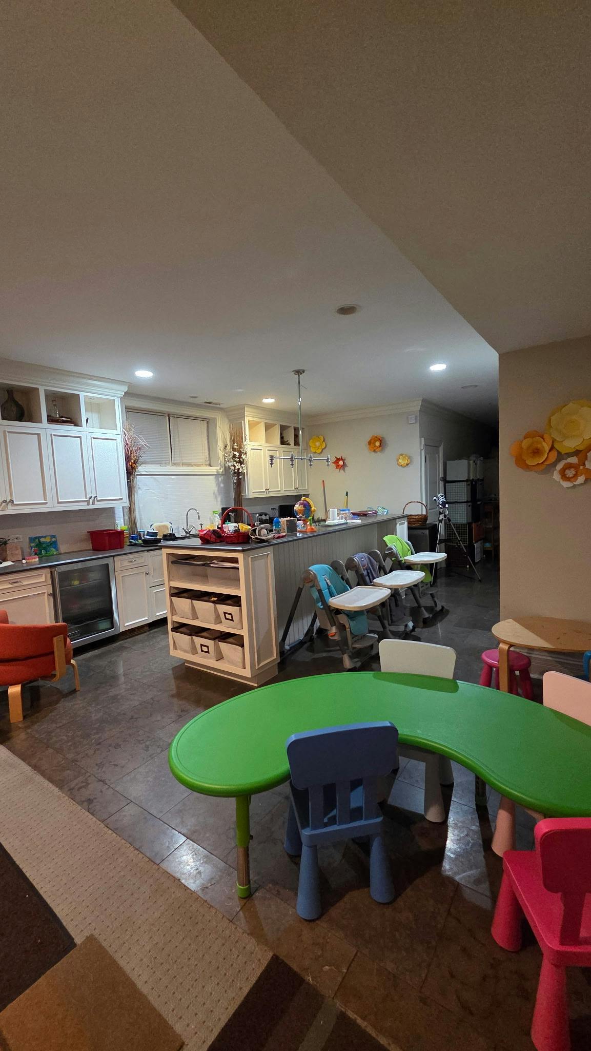 Kitchen with white cabinets and a green children's table with chairs
