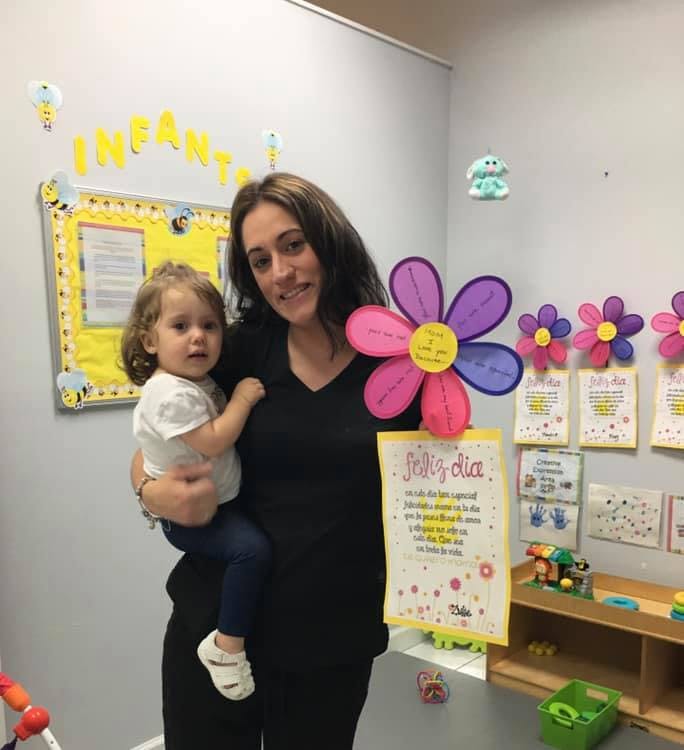 Person holding a child in a classroom
