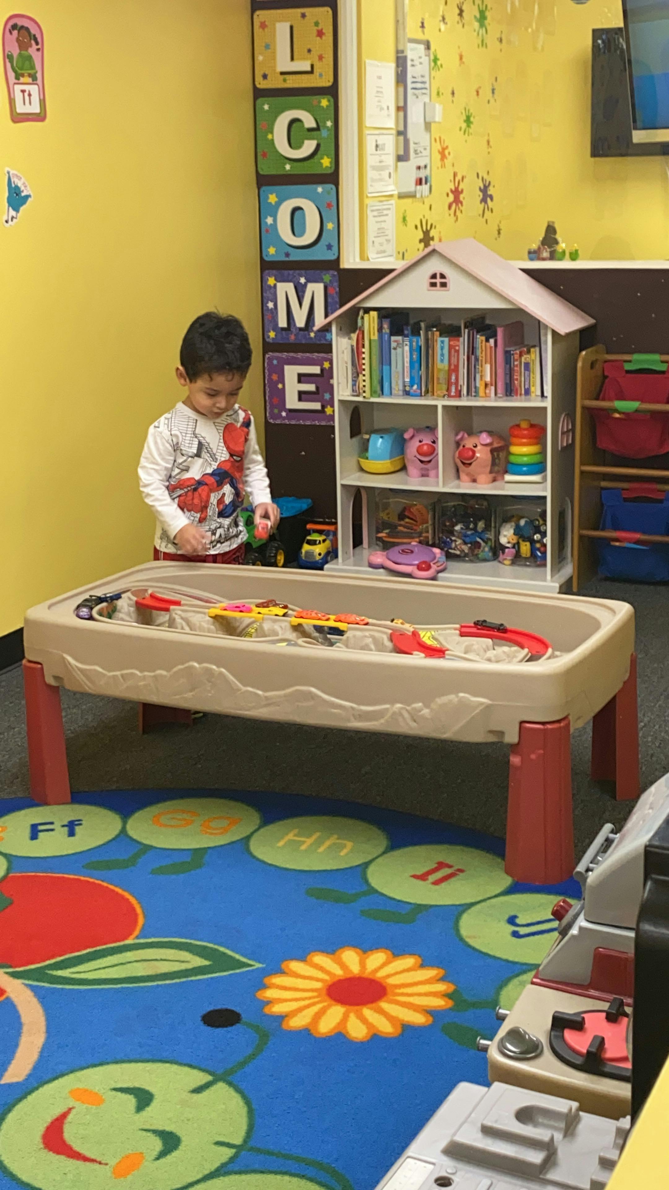 Child playing at a sand and water table in a classroom