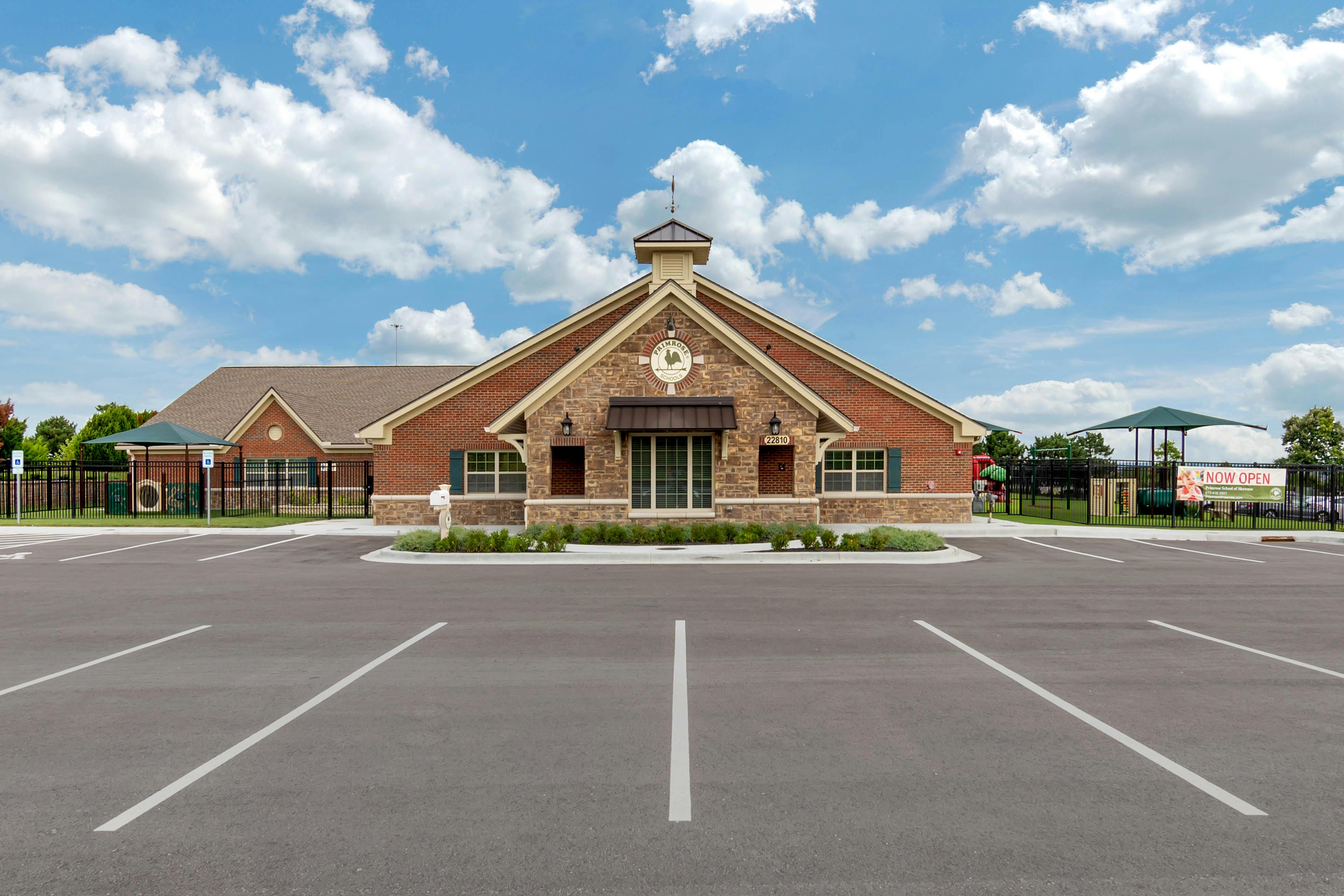 Brick school building with an empty parking lot in the foreground