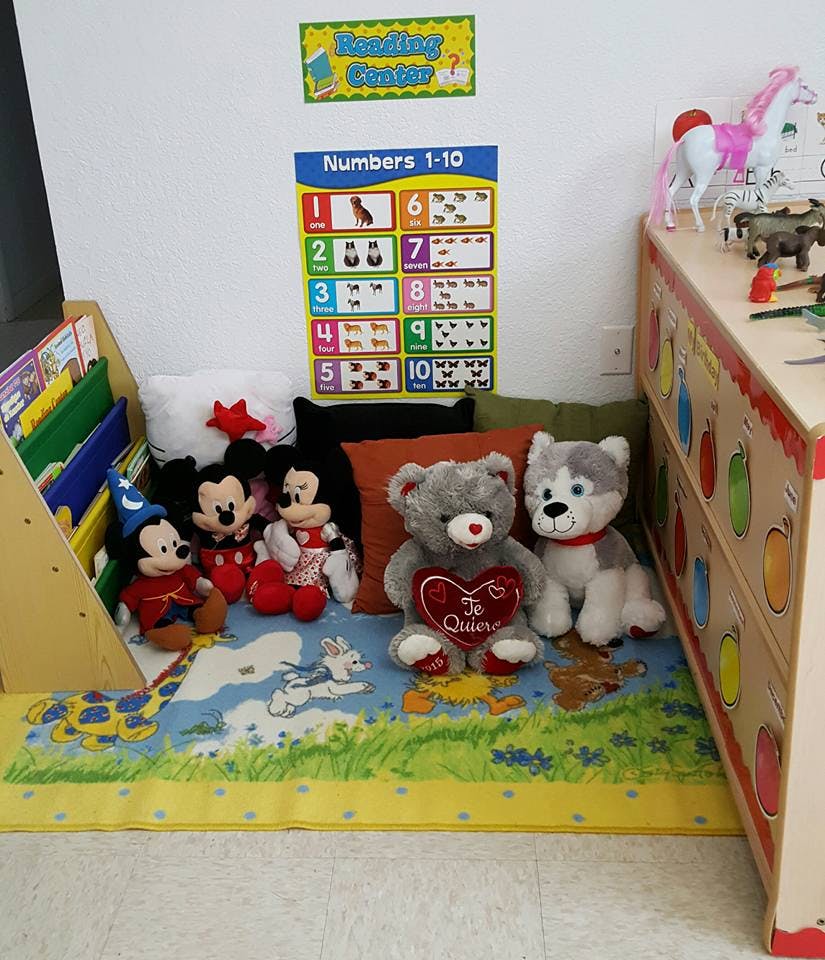 Stuffed animals on a colorful rug in a classroom corner