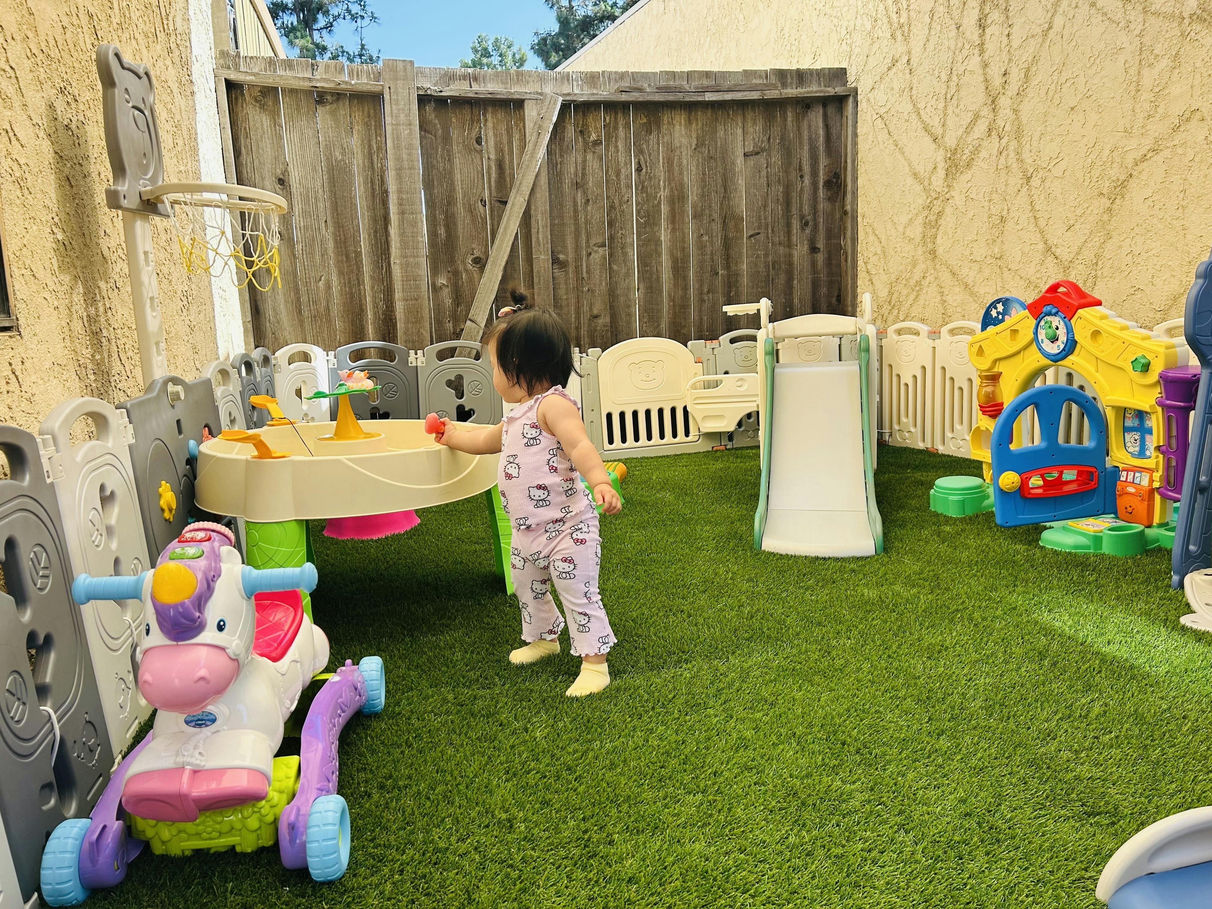 Child standing on artificial grass in an outdoor play area