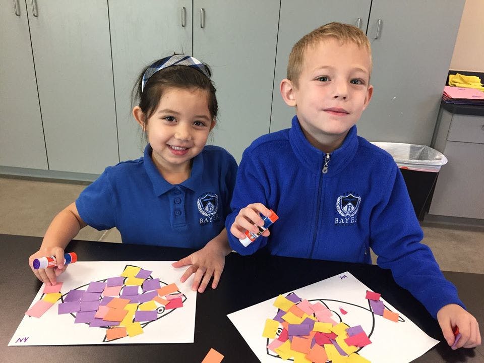 Two children making paper collages