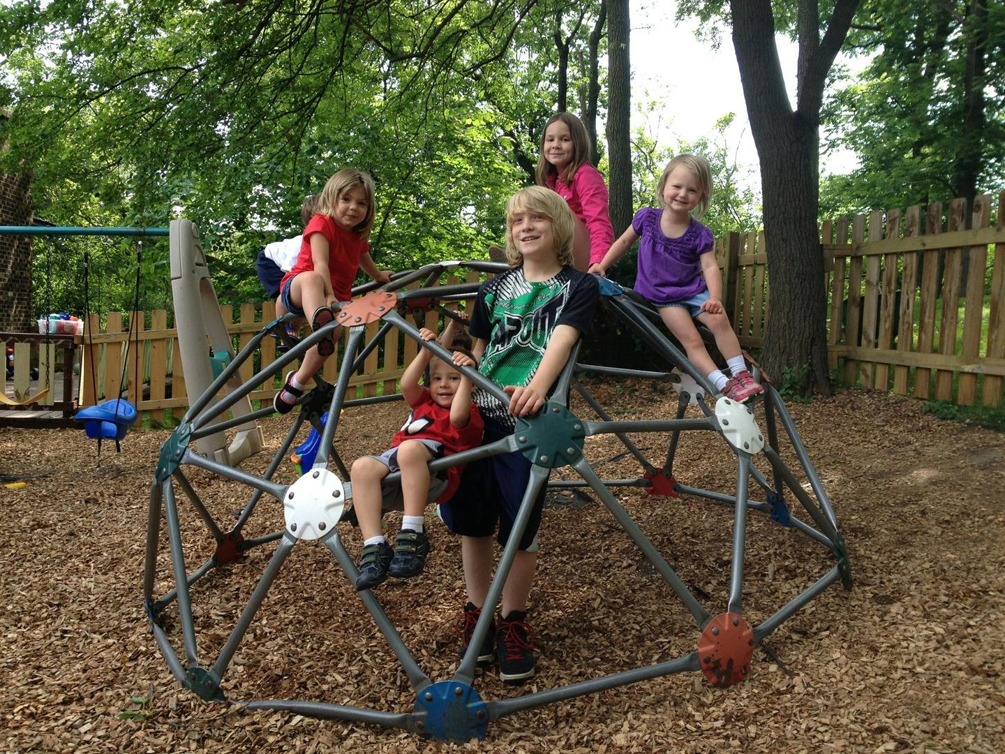 Children playing on a geodesic dome climber