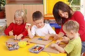 Adult and three children doing crafts at a table