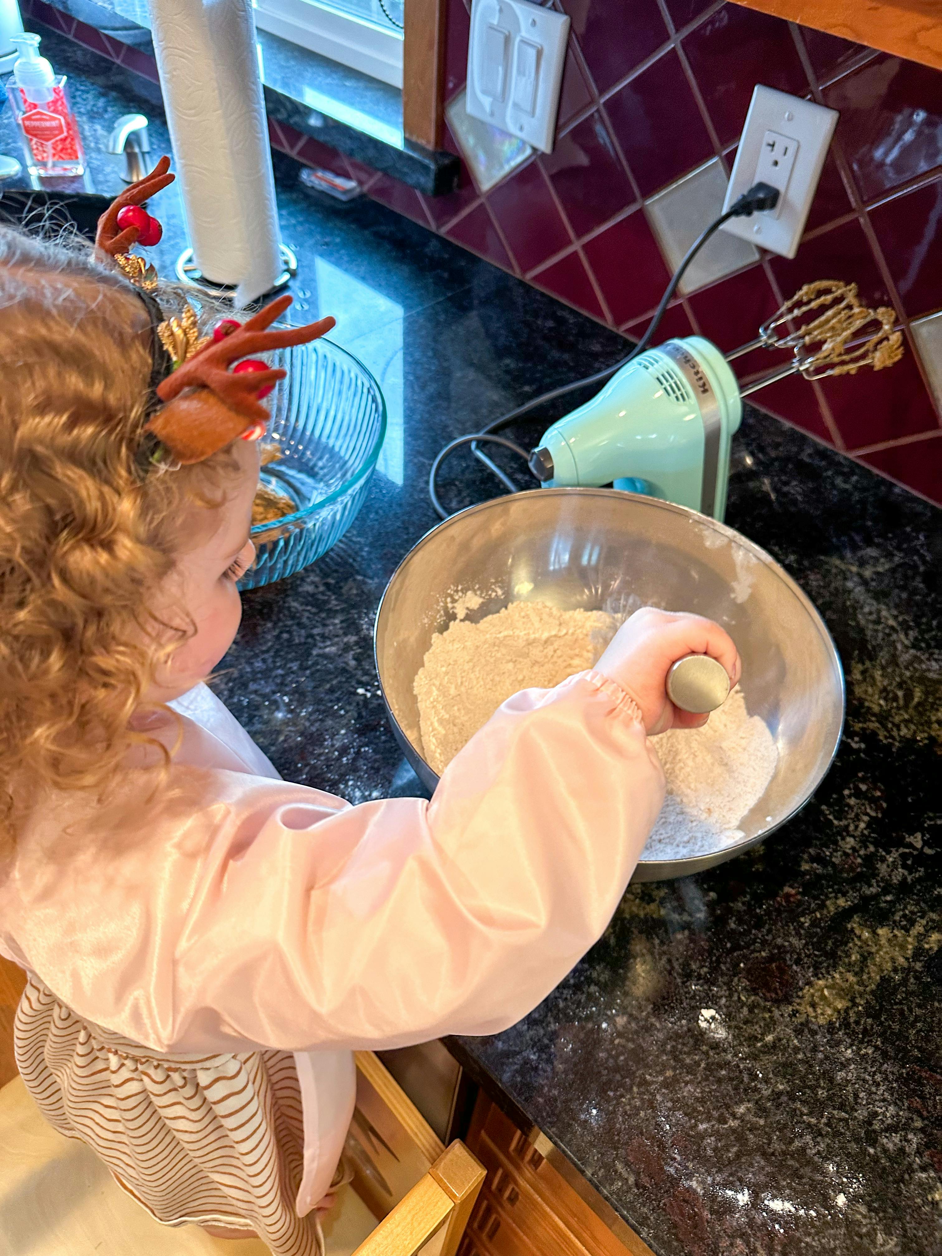 Child mixing ingredients in a bowl on a kitchen counter