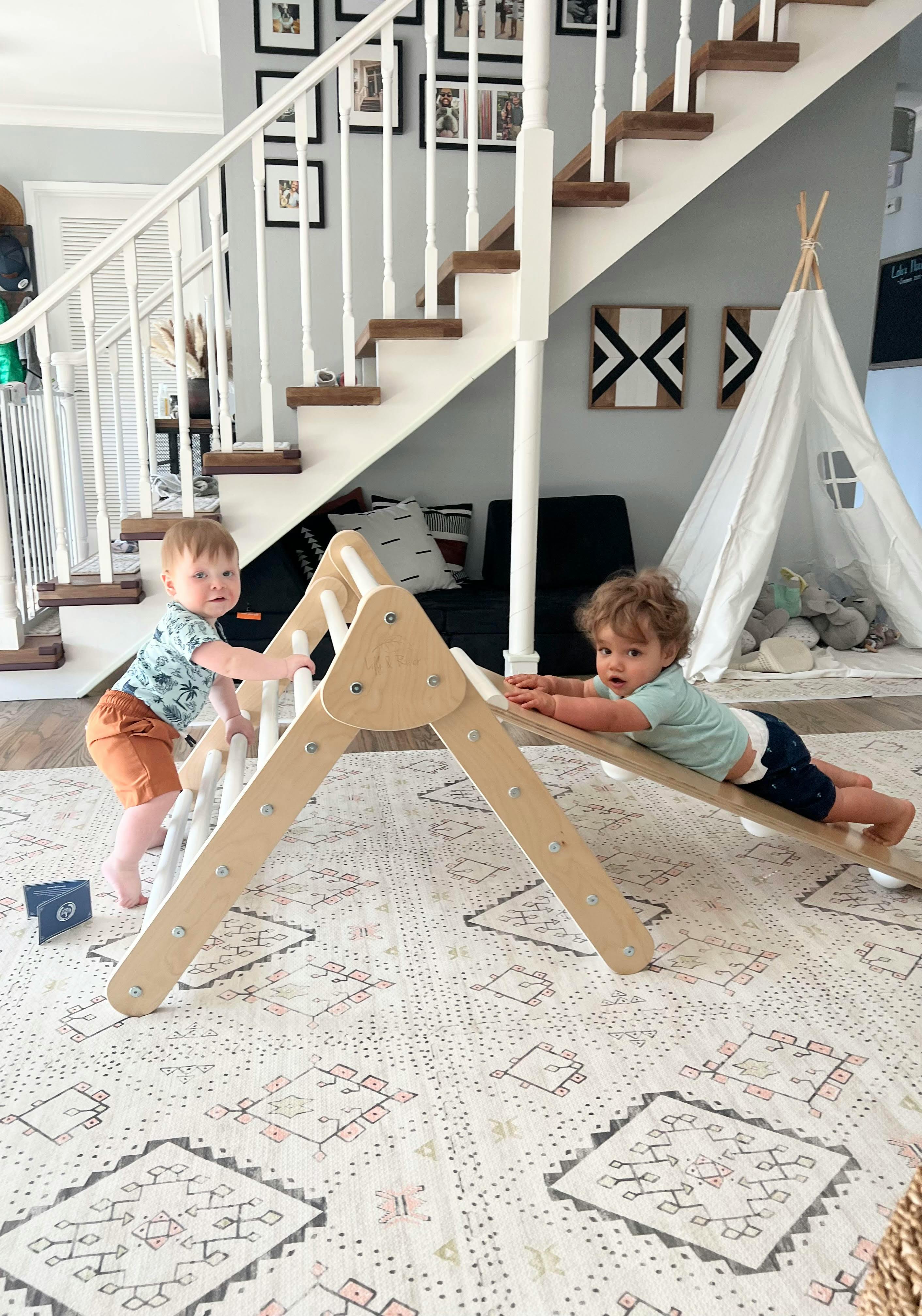 Two children playing on a wooden climbing structure