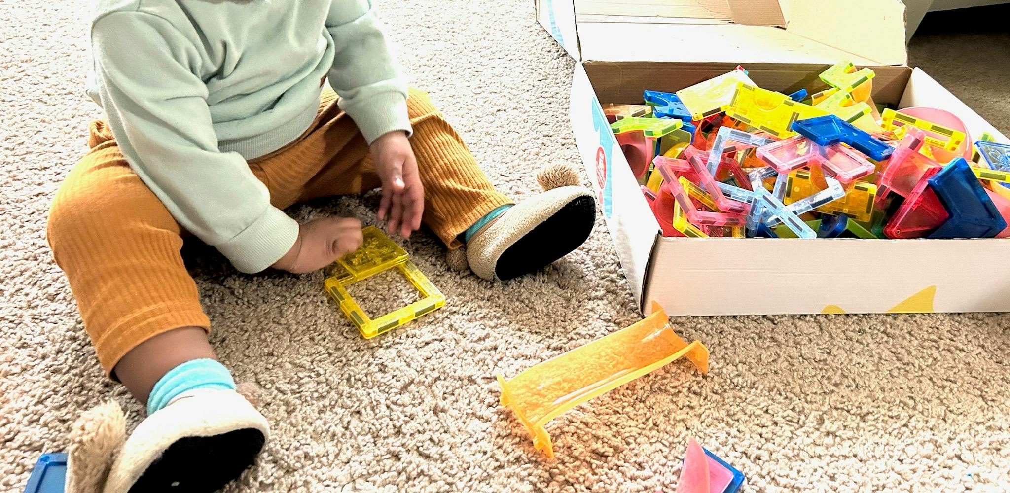 Child playing with colorful building blocks on a carpet