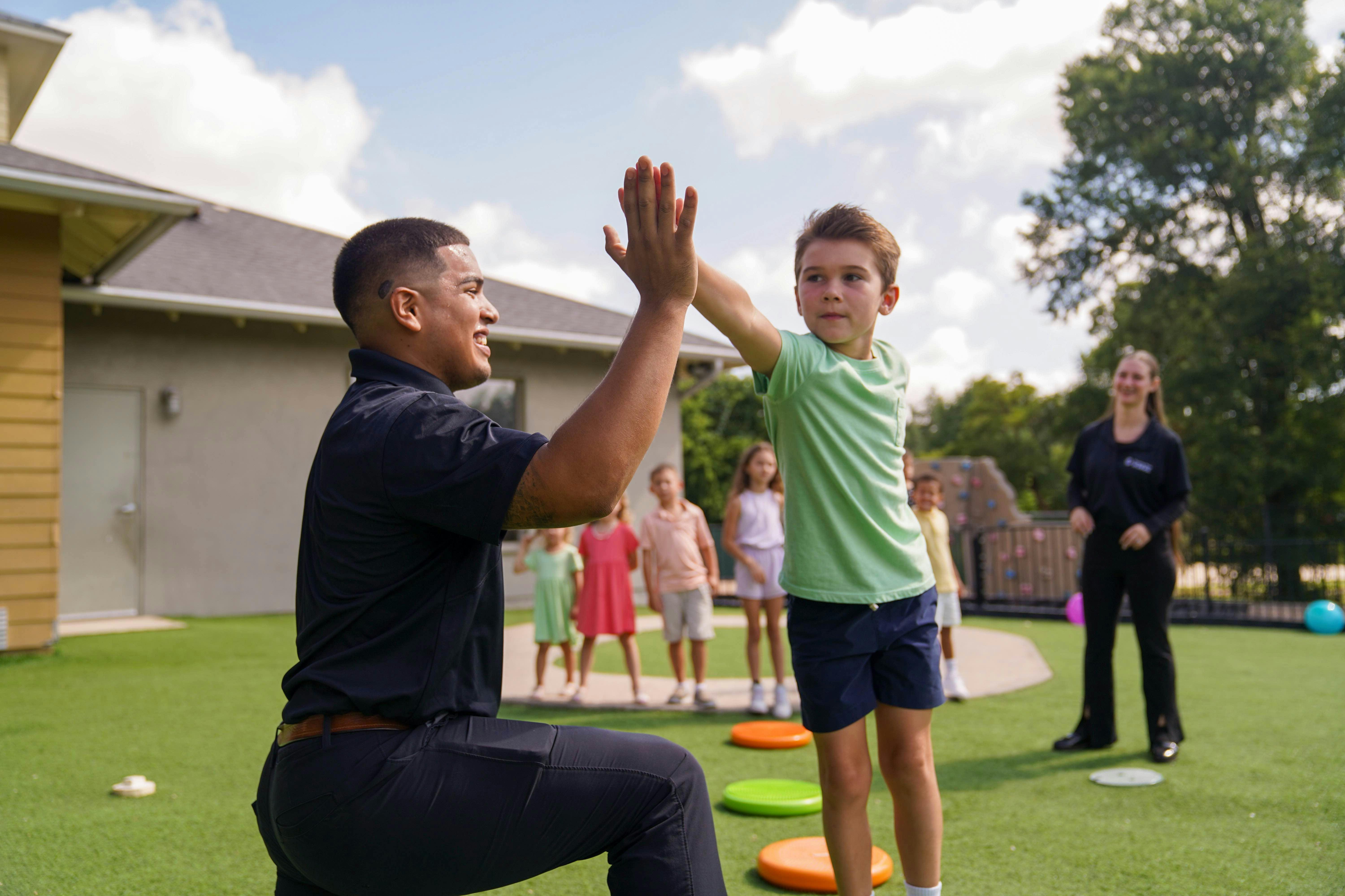 Man and child giving high five on a playground