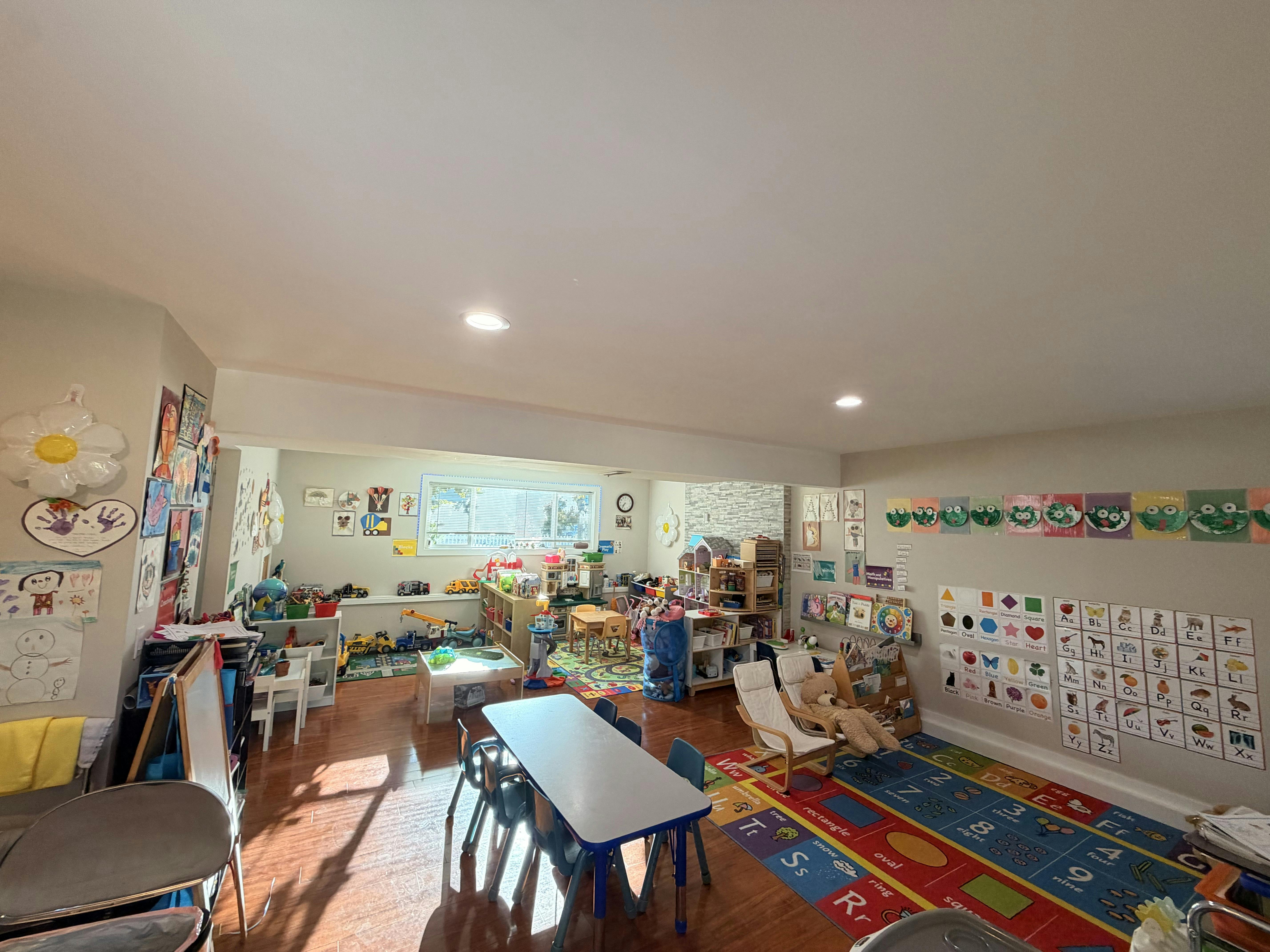 Classroom interior with educational rugs, small tables, and learning charts