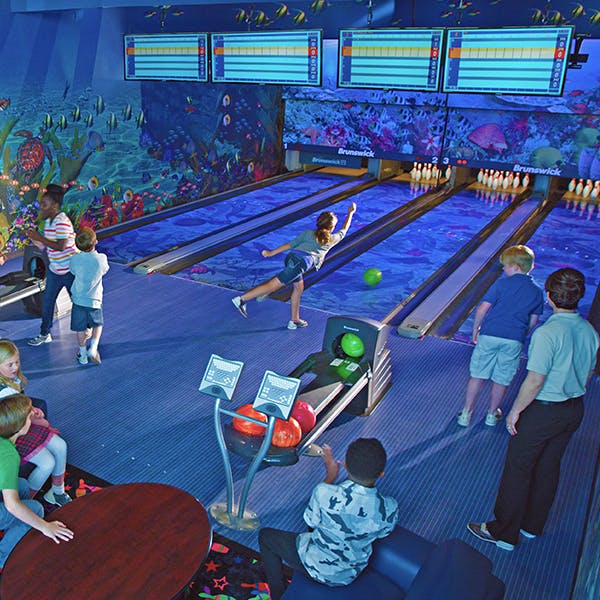 People bowling in a dimly lit alley
