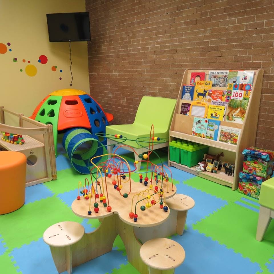 Children's play area with colorful toys, books, and soft flooring