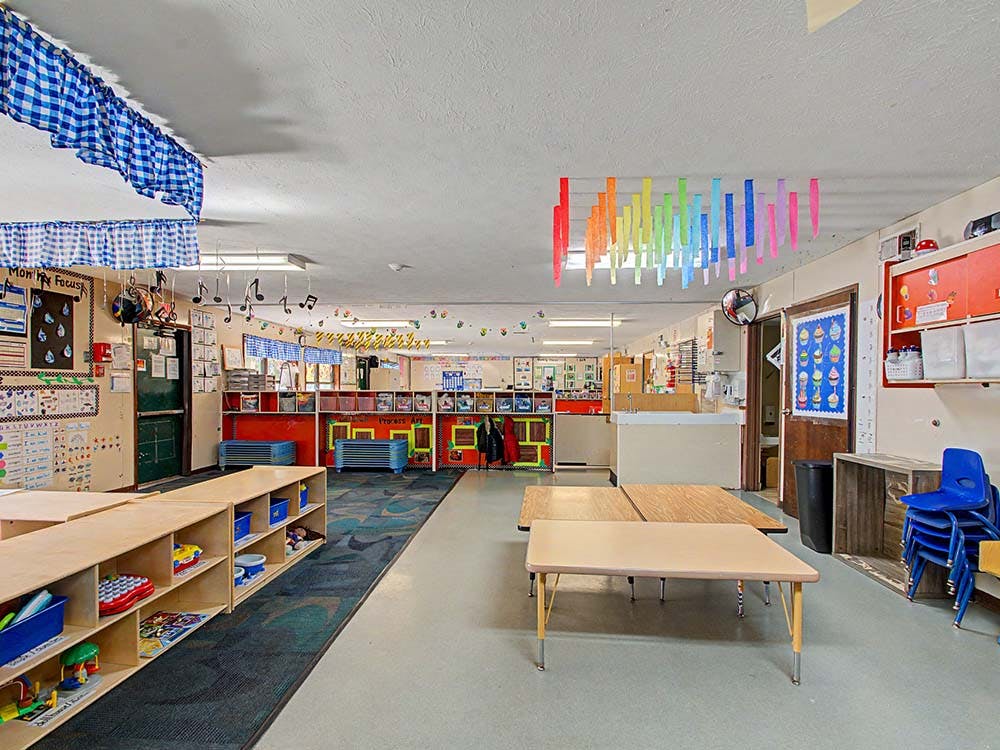 Classroom with tables, shelves, and colorful decorations