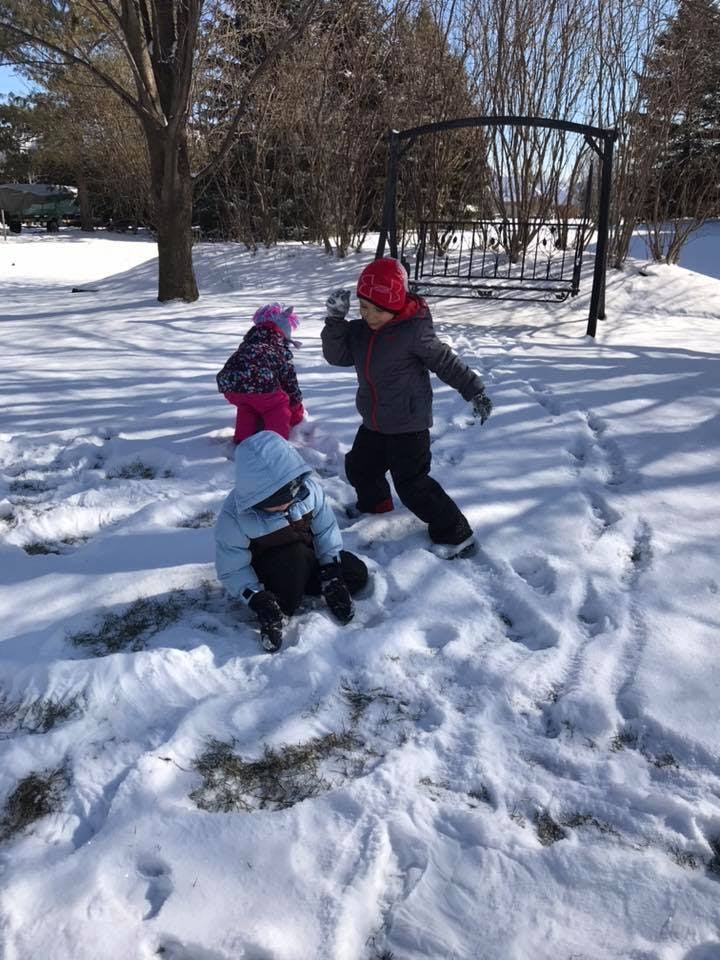 Three children playing in the snow