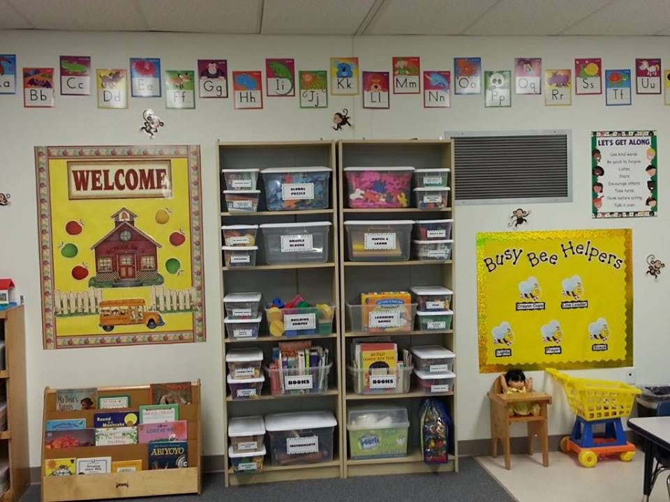 Classroom with shelves of storage bins, welcome sign, and bulletin boards