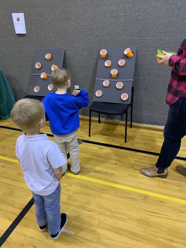 Two children playing a game with cups on a board