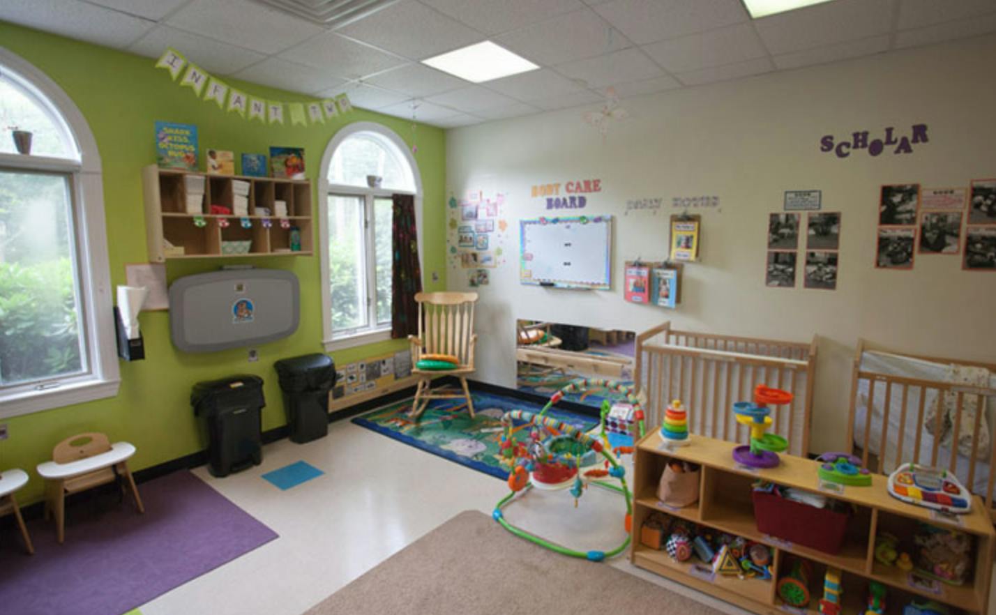 Nursery room with cribs, changing station, and play area