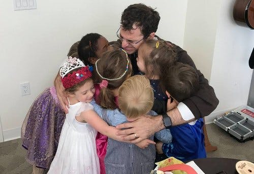 Person hugging multiple children