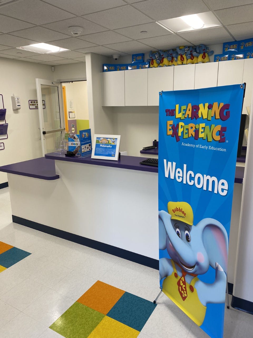 Reception desk with a welcome banner for The Learning Experience