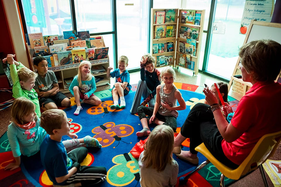 Adult reading to a group of children in a classroom