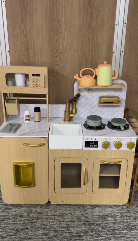 Child's play kitchen with microwave, sink, and stove