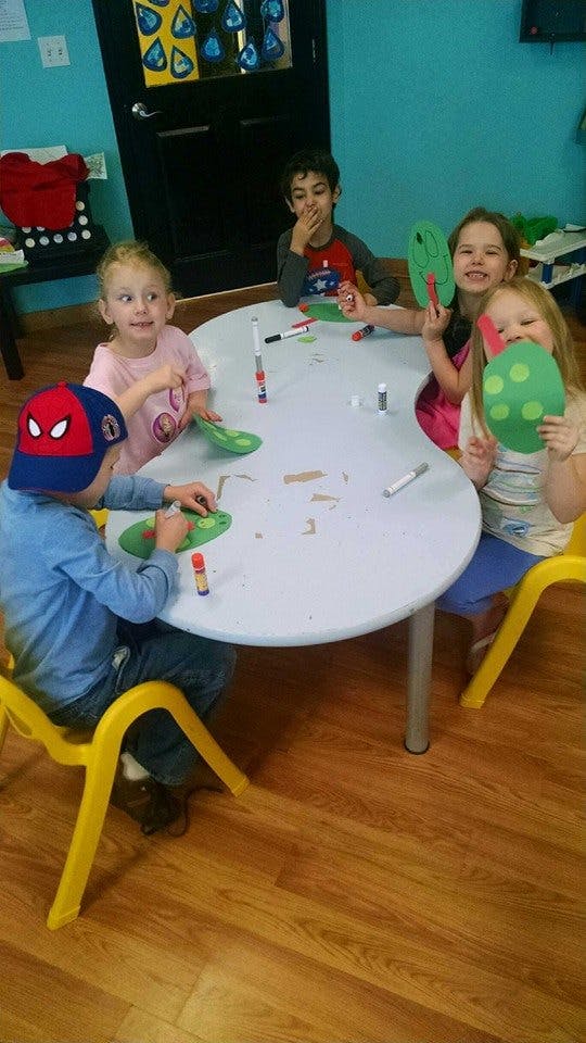 Children sitting around a table doing crafts